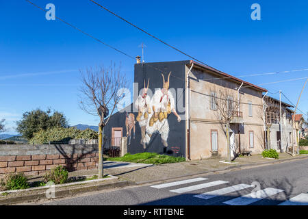 Sardinia Italy on December 27, 2019: Murals painted on houses in the streets of Tinnura depicting moments of rural and village life Stock Photo