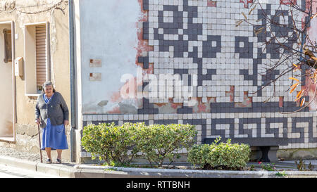 Sardinia Italy on December 27, 2019: Murals painted on houses in the streets of Tinnura depicting moments of rural and village life Stock Photo