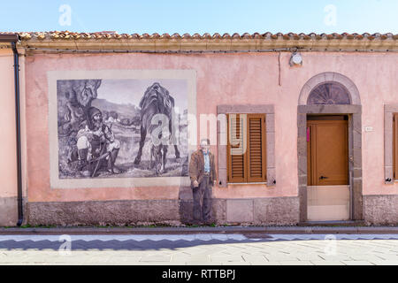 Sardinia Italy on December 27, 2019: Murals painted on houses in the streets of Tinnura depicting moments of rural and village life Stock Photo