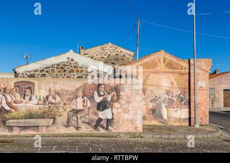 Sardinia Italy on December 27, 2019: Murals painted on houses in the streets of Tinnura depicting moments of rural and village life Stock Photo