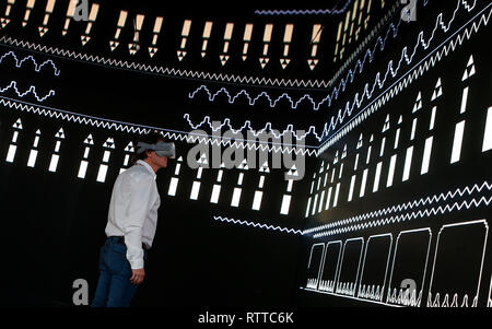 A man checks VR experience inside Saudi Telecom Company (STC) booth at the Mobile World Congress in Barcelona, Spain, February 26, Stock Photo