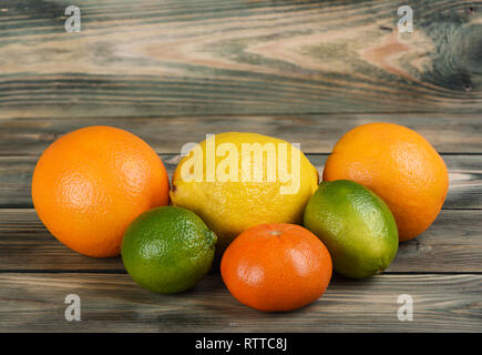 Several citrus fruits: oranges, tangerines, lemon and limes on a wooden table. Copy space. Rustic style. Stock Photo