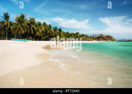 Tropical Malcapuya island with traditional philippines bangka boat, azure water and white sand beach. Travel vacation at Philippines. Stock Photo