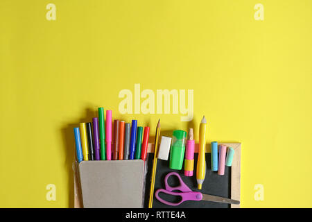 Education or back to school concept : top view or flat lay of chalks, pencil, magic colors, eraser, oil pastels, scissors, notebook with copy space Stock Photo