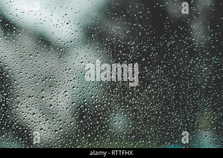 Water drops on windows close up against dark gray blurry background Stock Photo
