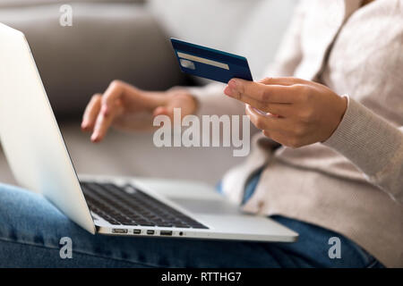Close up woman shopping, paying by credit card online, using laptop Stock Photo