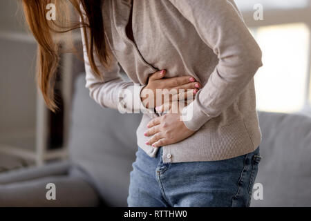 Close up woman holding belly, feeling pain, health problem concept Stock Photo