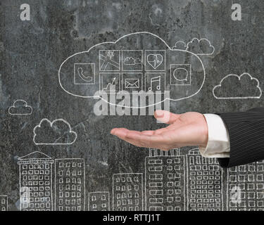 Man hand showing cloud with app icons doodles on mottled wall background Stock Photo