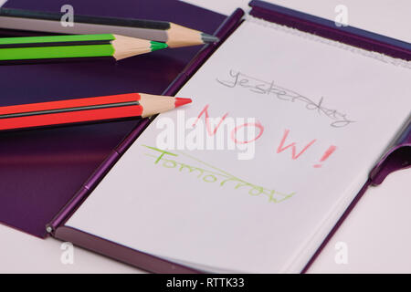handwritten text with the words: yesterday, now and tomorrow on a white notepad as a concept to live in the moment Stock Photo