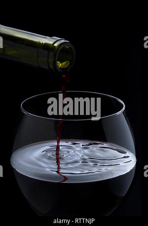 Red wine pouring down from a bottle Stock Photo