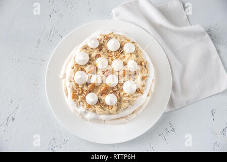 Pavlova cake with caramel and almonds on the wooden background Stock Photo