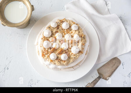 Pavlova cake with caramel and almonds on the wooden background Stock Photo
