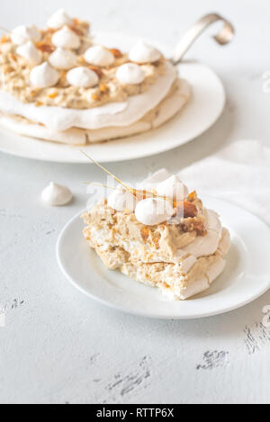 Pavlova cake with caramel and almonds on the wooden background Stock Photo