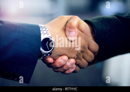 Close up of hispanic business man shaking hands in formal suits after closing deal at the office Stock Photo