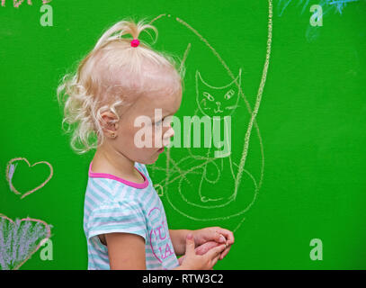 Dnipro, Ukraine - June 27, 2018: Little girl draws funny scribbles on the day of putting into operation an inclusive city park Stock Photo