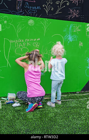 Dnipro, Ukraine - June 27, 2018: Little girls draws funny scribbles on the day of putting into operation an inclusive city park Stock Photo