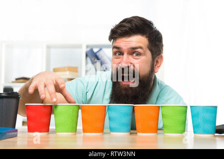 Pick one. Diversity and recycling. Eco paper cup. Coffee to go paper cup. How many cups per day. Choose from alternatives. Man bearded choosing one of lot colorful paper cups. Alternative concept. Stock Photo