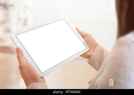 Tablet mockup closeup. White tablet in woman hands. room and sunlight in background. Stock Photo