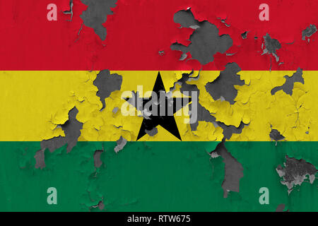 Close up grungy, damaged and weathered Ghana flag on wall peeling off paint to see inside surface. Stock Photo