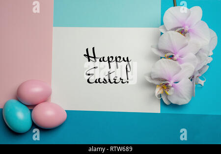 Pink blue easter eggs on pastel color background frame with space for happy easter text and white orchid Stock Photo