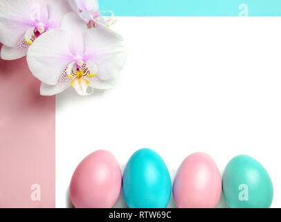 Pink blue easter eggs on pastel color background with space for text and white orchid Stock Photo