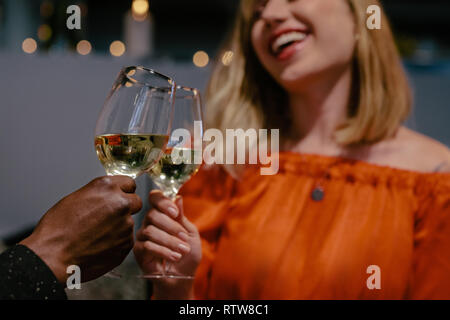 Man and woman toasting on date night. Smiling woman toasting glass of wines with her boyfriend. Stock Photo