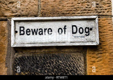 A humorous take on a beware of dog sign with extra text added .Beware of woman defaced graffiti,Glasgow city Scotland UK Stock Photo