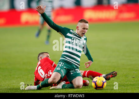 Ivan Petryak of MOL Fehervar FC dribbles between Franck Boli of