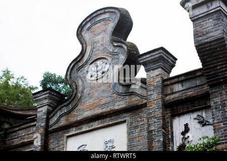 Elaborate Design of Curved Front Gable Wall of Traditional Chinese Building in Chengdu. Grey and Red Bricks with Ornaments and Relief. Stock Photo