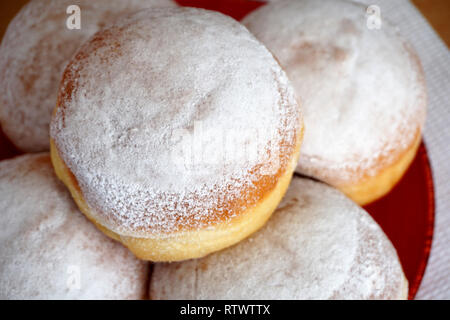 Tasty donuts powdered with white ground sugar on a plate, close up view Stock Photo