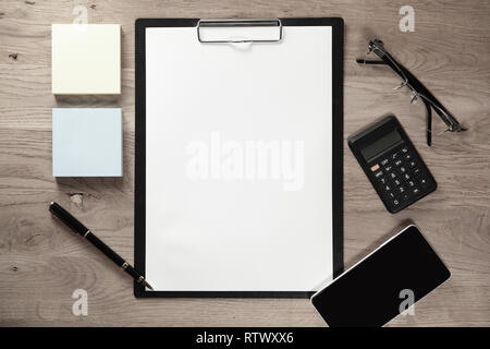 clipboard with blank sheet and business items on wooden background Stock Photo