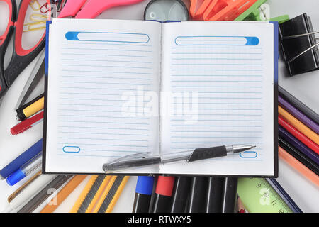 opened Notepad on office supplies on white background Stock Photo