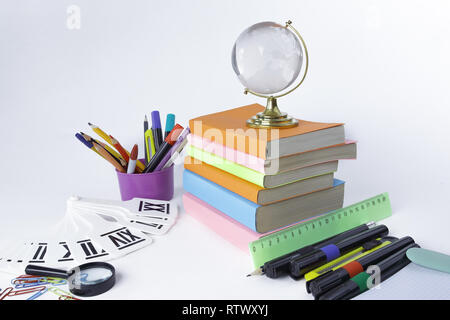 glass globe, books and school supplies on white background Stock Photo