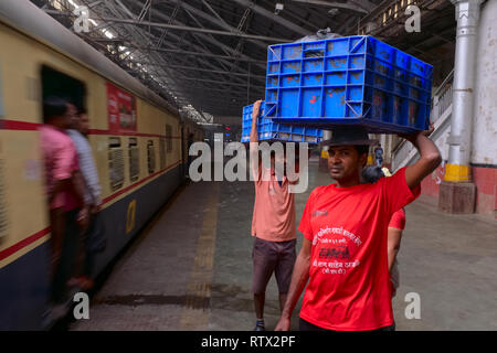 Porters waiting to deliver goods at Chhatrapati Shivaji Maharaj Terminus (CSMT) in Mumbai, India, the city's busiest railway station Stock Photo