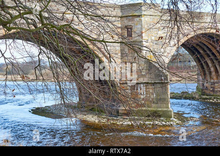 BRIDGE OF DEE A90 ROAD OVER RIVER DEE ABERDEEN SCOTLAND THE ARCHES OF THE OLD BRIDGE AND TREE BRANCHES IN EARLY SPRINGTIME Stock Photo