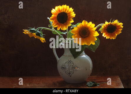 Still life with decorative sunflowers in a white jug Stock Photo