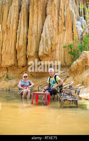 NAM TIEN, VIETNAM - FEBRUARY 15, 2018: Tourist sit on chairs in a river called Fairy Stream in Nam Tien, Vietnam on February 15, 2018 Stock Photo