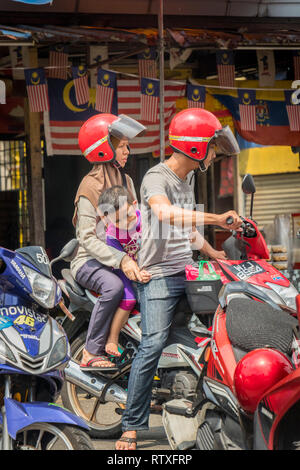 couple riding with small child on scooter in Kuala Lumpur Malaysia Stock Photo