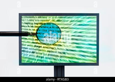 Computer screen with programming and magnifying glass. Stock Photo