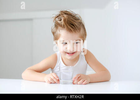 Cute smiling boy with glass of water isolated on a white background. Stock Photo