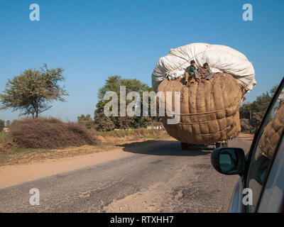 Overloaded truck with psassengers on a country road in Rajasthan. Trucks carrying heavy loads characterize traffic in India. Stock Photo