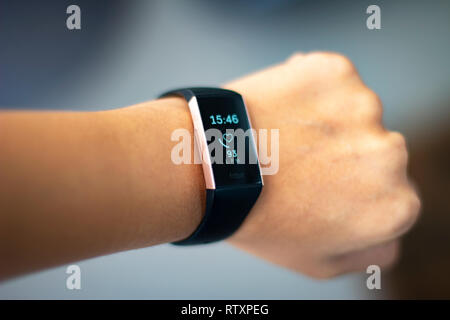 Close up of woman monitoring her heart beat with a fitbit wearable fitness tracker Stock Photo