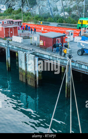 September 15, 2018 - Skagway, Alaska: Cruise ship mooring lines tied to White Pass dock with early morning sightseeing tourists departing on foot. Stock Photo