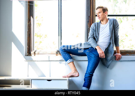 A young handsome male Dancer resting in a modern Loft Apartment Stock Photo