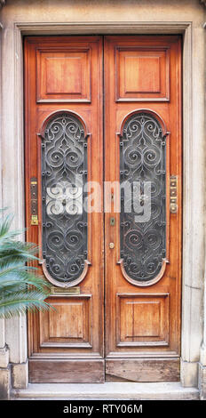 antique door with window and wrought iron grille Stock Photo