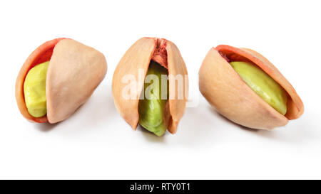 Three red turkish pistachios, peeled green nuts visible in cracked shells isolated on white background. Stock Photo