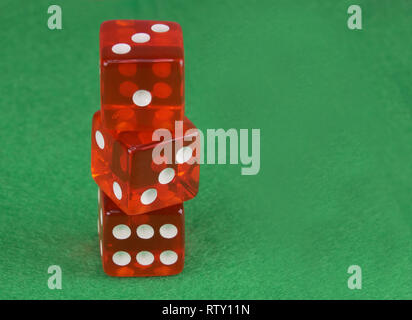 Three red casino dices on green cloth. The concept of online gambling. Copy space for text. Stock Photo