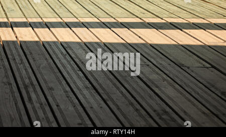 Regular exterior wooden board floor, sun casting shadow from side. Stock Photo