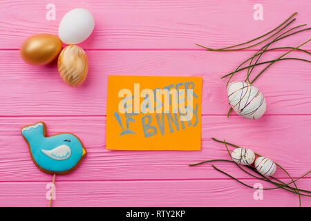 Easter festive background with decorations. Easter various eggs on pink wooden table. Easter bunny card. Creative Easter craft. Stock Photo