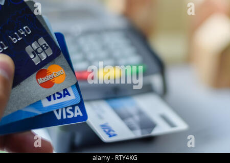 Bangkok, Thailand - March 3, 2019: Group of credit cards on Credit Card Machine with VISA ,Master Card and JCB brand logos close up Stock Photo